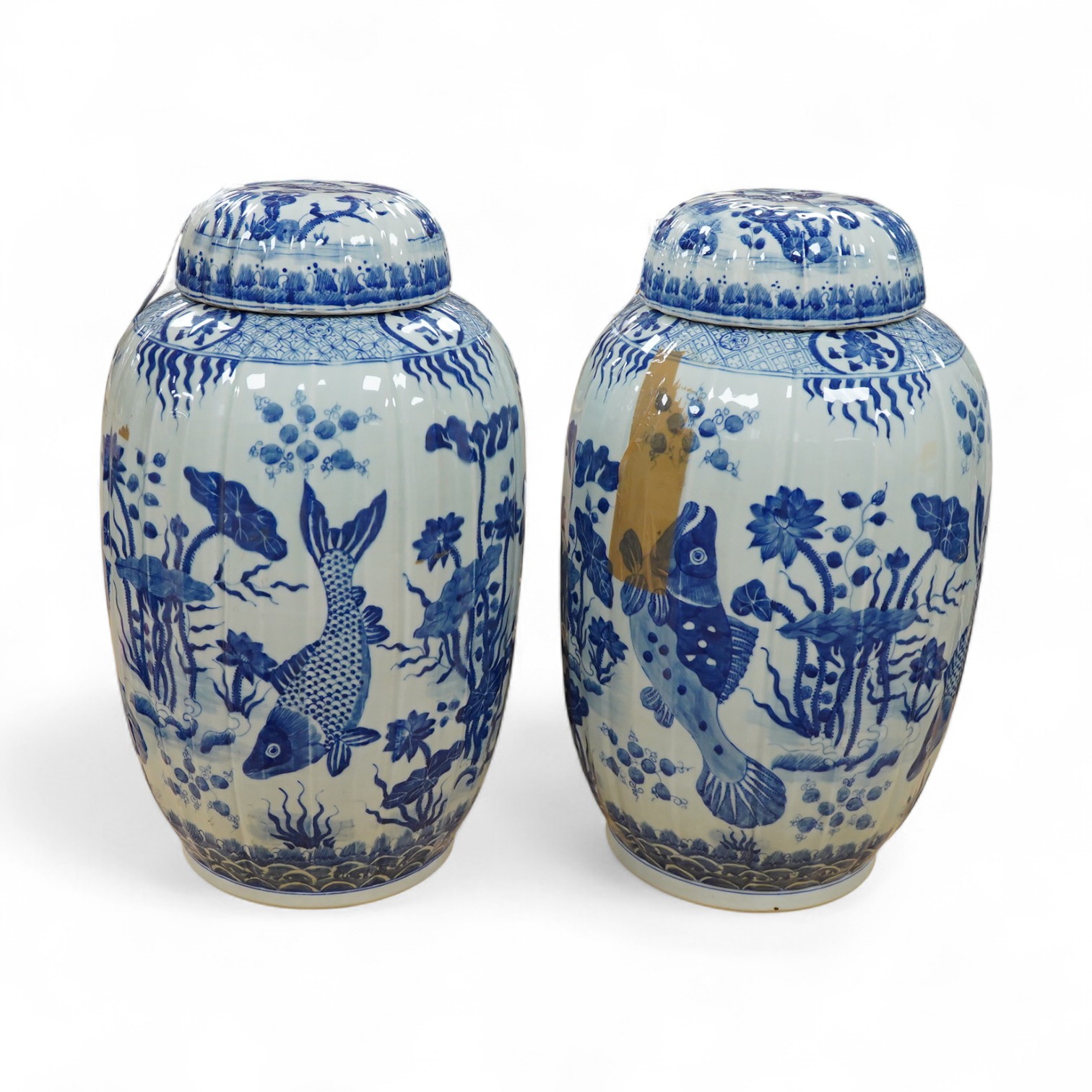 A large pair of Chinese blue and white ovoid jars and covers decorated with fish and lotus, 48cm high